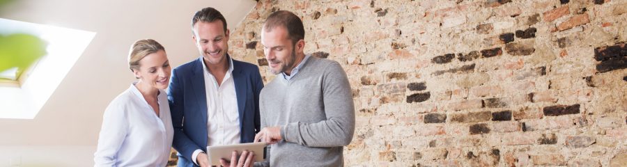 Architect with tablet presenting tablet to end customer at studio in attic loft