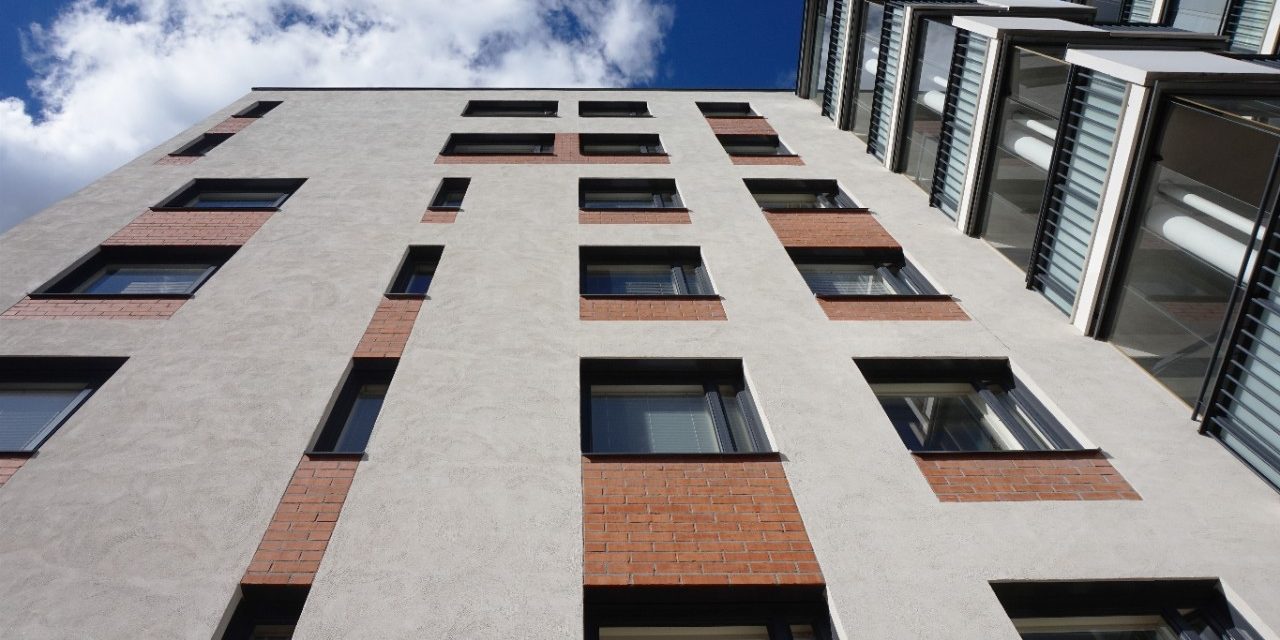 Building with light plastering over brick facade