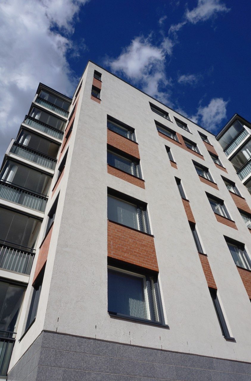 Building with light plastering over brick facade