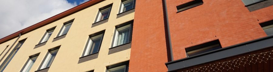 Building with light plastering over brick facade