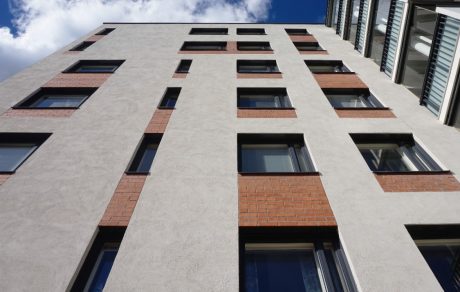 Building with light plastering over brick facade