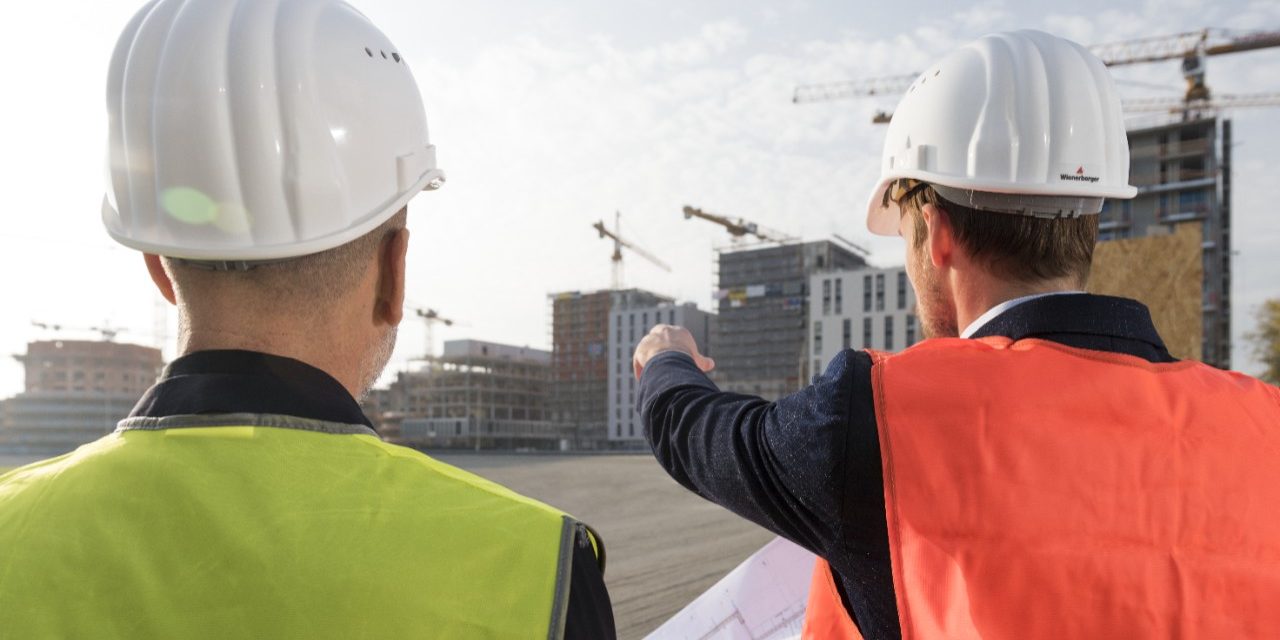 Businessman and architect talking about new building projects at a construction site